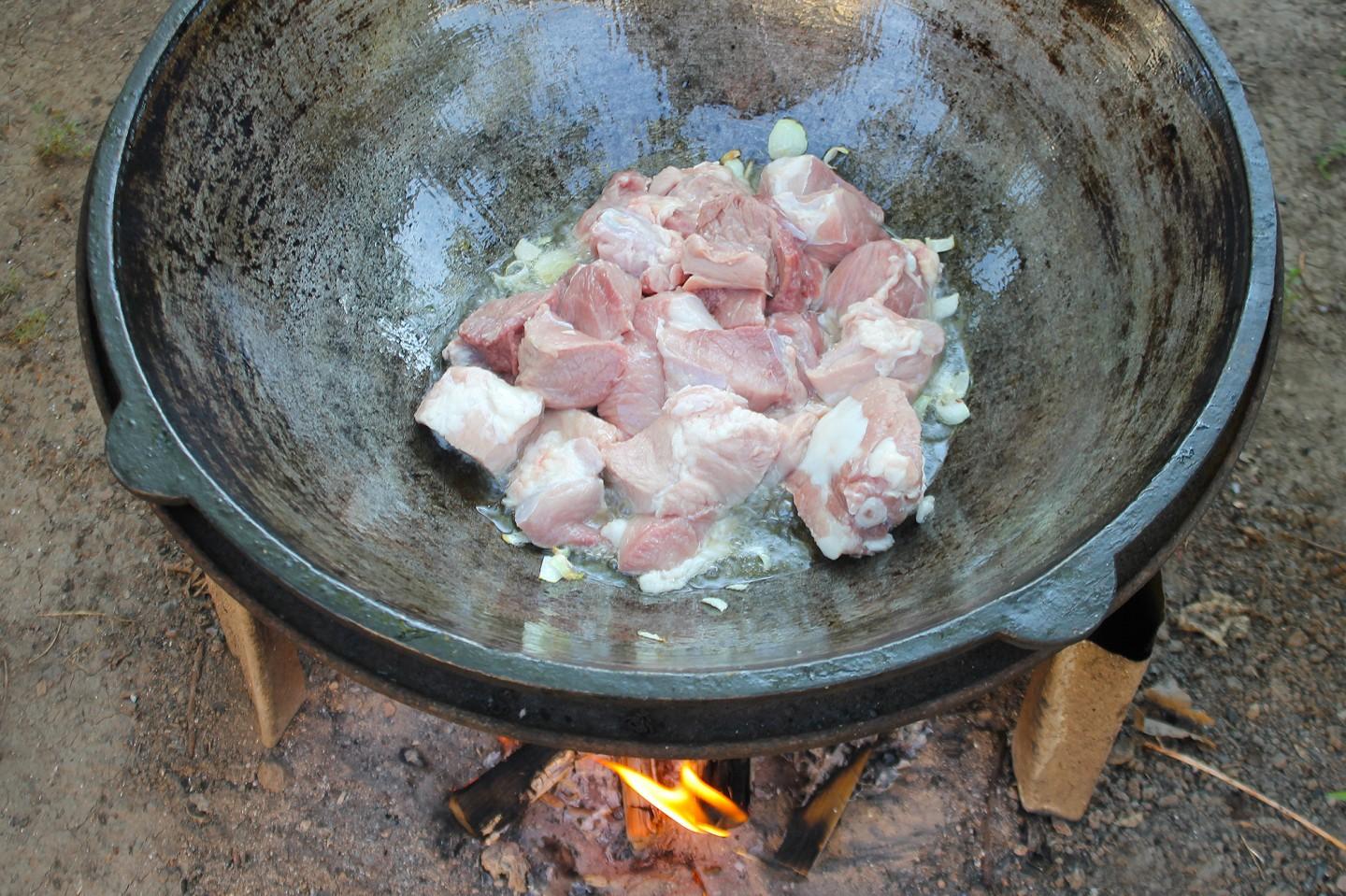Шаг 5 приготовления Тушеные овощи в казане на костре с мясом