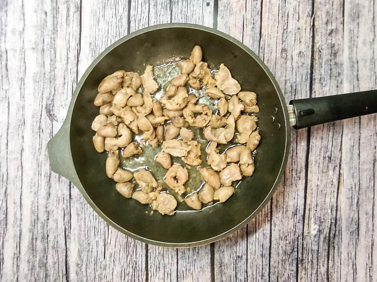 Шаг 5 приготовления Куриные желудки и сердечки тушеные на сковороде в сметане